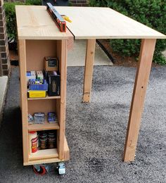 a workbench made out of plywood with tools and supplies on the floor