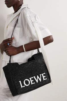 Loewe's tote is an easy swap to make with your favorite leather style this summer. Part of the latest collaboration with Paula's Ibiza, it's woven from black raffia in a structured shape and embroidered with the label's unmistakable logo in optic white lettering. Attach the shoulder strap on sightseeing trips. Loewe Paula's Ibiza, Handbag Crochet, Knit Bags, Office Inspo, Loewe Bag, Woven Raffia, Raffia Bag, Embroidered Bag, Leather Style