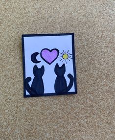 a piece of paper that has been cut into two cats with a heart on it