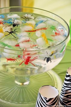 there is a glass bowl filled with water and plastic animal figures in the bottom half