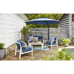 a patio with blue chairs and an umbrella