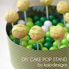 cake pop stand with green and white candies in a cupcake tin filled with candy