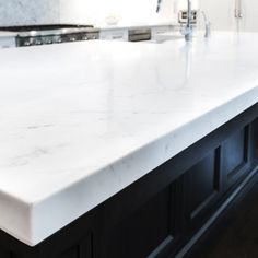 a white counter top in a kitchen with black cabinets