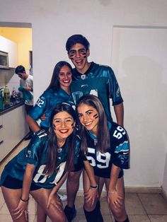 a group of young people standing next to each other wearing football uniforms and posing for a photo