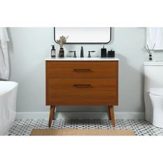 a white toilet sitting next to a wooden cabinet in a bathroom with a mirror above it