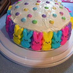 a cake with white frosting decorated with peep holes and candies on it