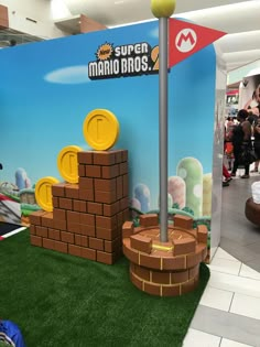 a display at an indoor gaming convention with mario bros on the wall and other decorations