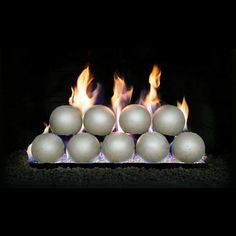 a bunch of white balls sitting on top of each other in front of a fire