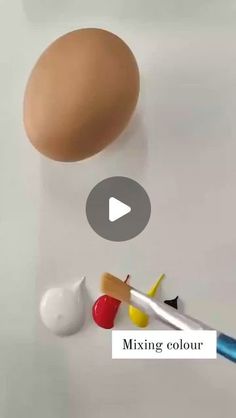 an egg and some paint on a white surface with the words mixingcolour written below it