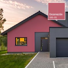 a pink and grey house with a for sale sign on it's front door