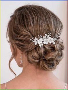 a woman wearing a wedding hair comb with flowers on the side and pearls in her hair