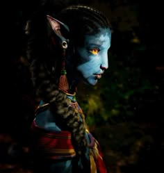 a woman with blue paint on her face and cat hair is standing in the dark