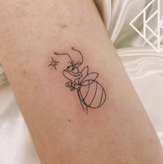 a tattoo on the arm of a person with a small insect in it's hand