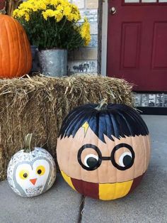 two pumpkins sitting next to each other on the ground near hay bales and flowers