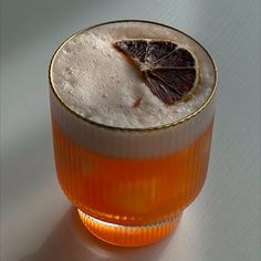 a drink in a glass with a slice of orange on the rim