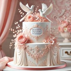 a white cake with pink flowers and two birds on top