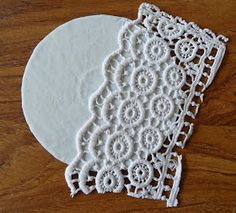 two white doily sitting on top of a wooden table