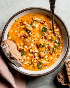 a bowl filled with soup next to some slices of bread