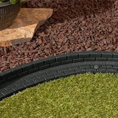 a close up of two black tires on the ground next to some green grass and rocks