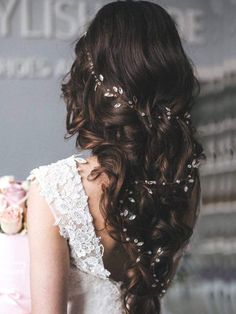 the back of a woman's head with flowers in her hair, wearing a wedding dress