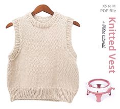 a knitted vest next to a measuring cup on a wooden hanger with the knitting pattern