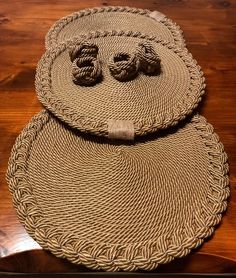 two woven placemats sitting on top of a wooden table