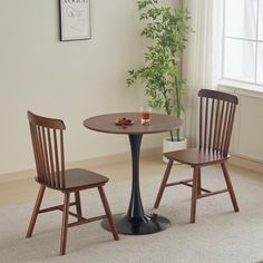 two wooden chairs and a small table in a room with white carpeted flooring