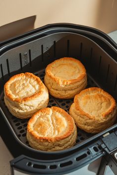 four biscuits sitting on top of an air fryer