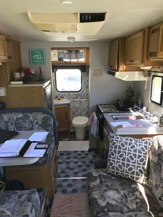 the inside of an rv with couches and kitchen