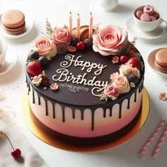 a birthday cake with candles and flowers on it, surrounded by other plates and desserts