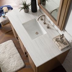 a bathroom with a sink, mirror and rugs on the floor in front of it