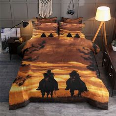 a bed with two cowboys riding horses in the sunset on it's comforter