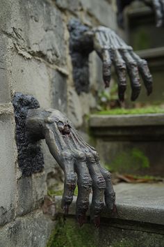 zombie hand coming out of the wall with green moss growing on it's fingers