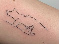 a black and white photo of a cat tattoo on the back of a woman's arm