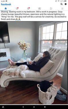 a woman sitting on a couch in front of a window