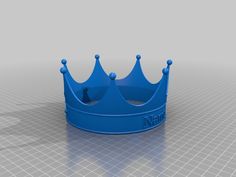 a blue plastic crown sitting on top of a white table next to a gray wall