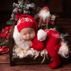 a baby is sleeping in a wooden crate with santa clause on it's back