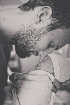 a black and white photo of a man holding a baby