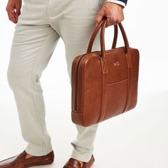 Handsome and distinguished, Carson is an elevated travel collection, made from gorgeous calf leather, with numerous practical details. The briefcase has classic styling with both a handle and adjustable carrying strap, plus multiple pockets and compartments for commuting or work travel. Make it even more personal with a laser-engraved monogram.  15"w x 2.5"d x 11.25"h  Please see Product Information for more dimensions.  Calf leather, cotton lining.  Lightly finished leather will age and patina Leather Briefcase, Travel Collection, Work Travel, Laser Engraved, Laser Engraving, Calf Leather, Patina, Monogram, Leather