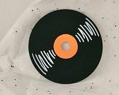 a black record with an orange disk on it