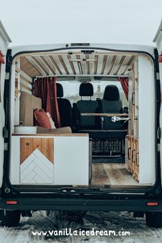 the back end of a van with its doors open and furniture in the cargo area