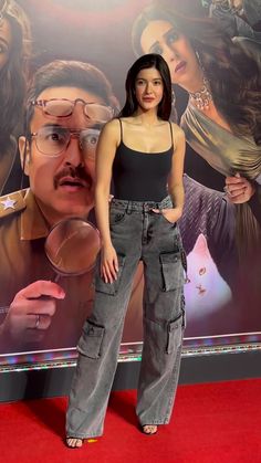 a woman standing in front of a movie poster