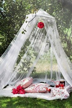 a canopy bed with flowers on it in the grass