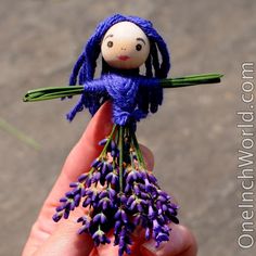 a tiny doll holding purple flowers in its hand