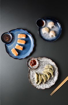 two plates with sushi and chopsticks next to each other