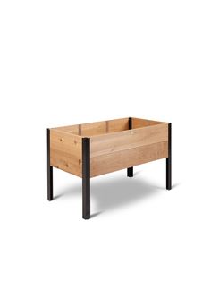 a wooden planter sitting on top of a white floor next to a black metal frame