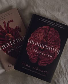 two books sitting on top of a bed next to each other