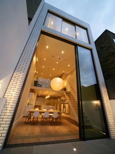 the inside of a modern house with glass doors and stairs leading up to an outdoor dining area