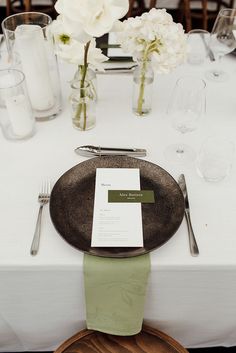 a place setting with white flowers and silverware