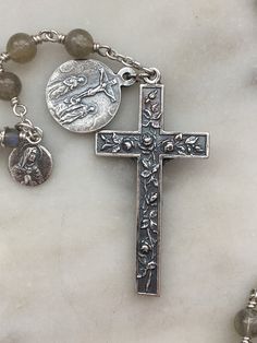 This beautiful chaplet is made with 5 and 8mm labradorite gemstones. The wire wrapping is done with 22 gauge sterling silver wire and chain. The bead caps and medals are sterling silver. These are the Seven sorrows and each is depicted on one of the medals: The prophecy of Simeon. (St. Luke 2:34, 35) The flight into Egypt. (St. Matthew 2:13, 14) The loss of the Child Jesus in the temple. (St. Luke 2: 43-45) The meeting of Jesus and Mary on the Way of the Cross. The Crucifixion. The taking down o Spiritual Wire Wrapped Crucifix Jewelry, Silver Spiritual Rosary For Healing, Spiritual Sterling Silver Rosary With 8mm Beads, Handmade Spiritual Silver Rosary, Handmade Silver Rosary For Healing, Silver Rosary With Natural Stones, Silver Rosary With Natural Stones As A Gift, Silver Rosary With Natural Stones For Gift, Silver Rosary With Natural Stones And Round Beads